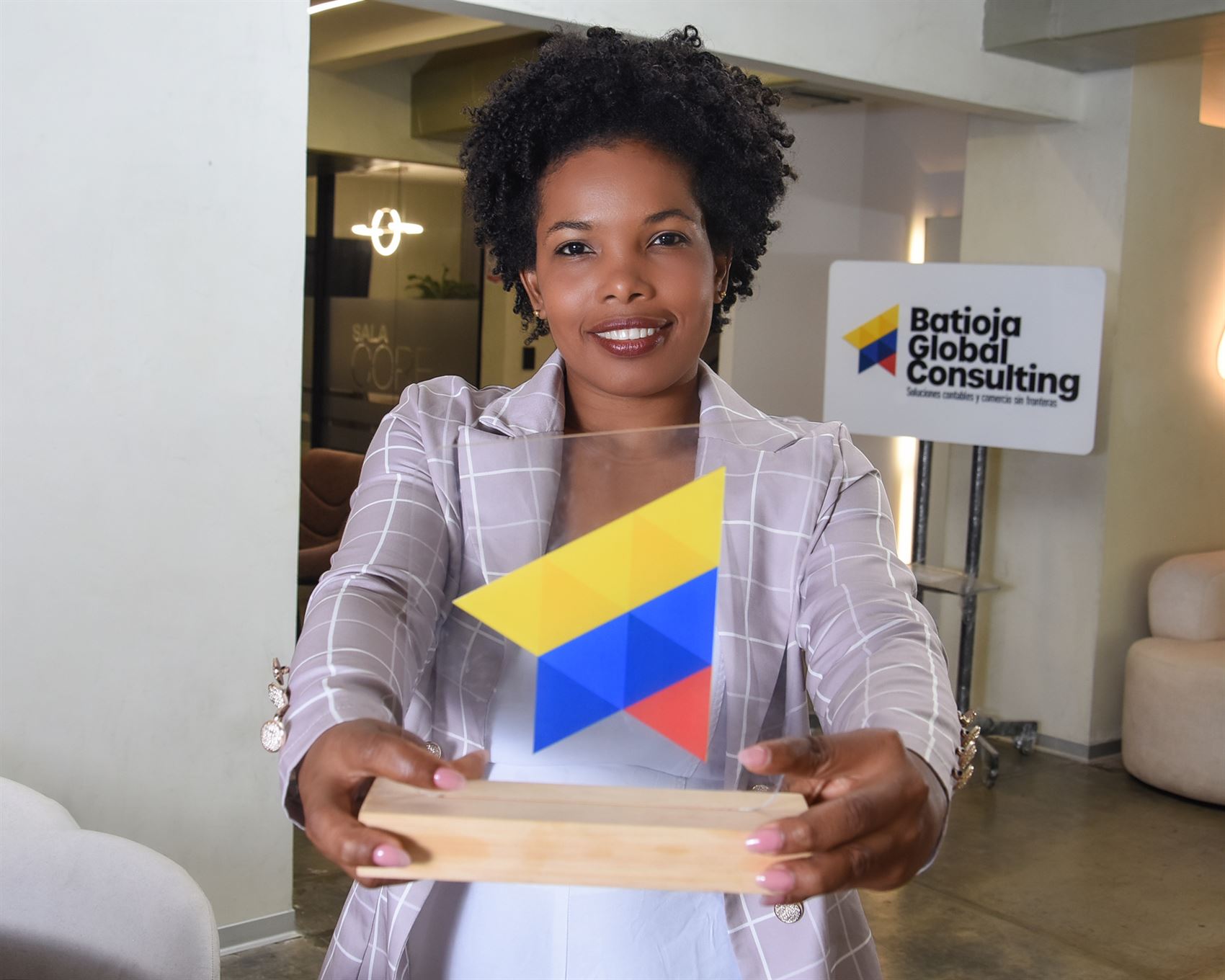 Luz Batioja sosteniendo el isotipo de Batioja Global Consulting
