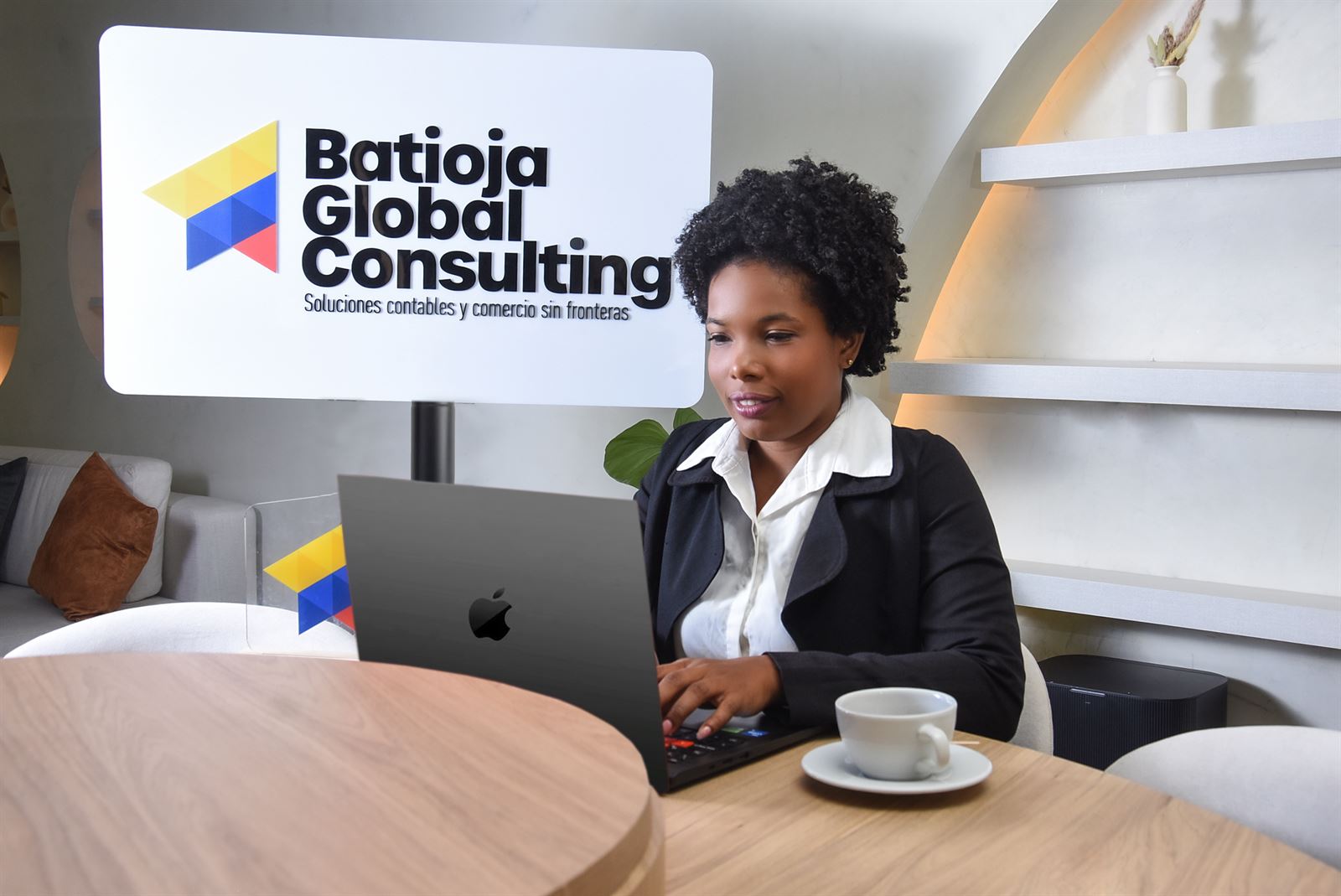 Luz Batioja trabajando junto al logo de Batioja Global Consulting